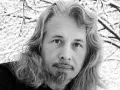 Vladimir Sorokin, med sitt långa hår och skägg, blickar ut mot en snötäckt vinterbakgrund.