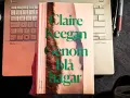 Claire Keegans bok "Genom blå hagar" ligger på ett tangentbord bredvid en anteckningsbok och pennor.