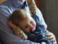 En pappa håller sin lilla dotter, som har en napp i munnen. Bilden känns som en dikt till min dotter.