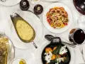 En festmåltid på Sture Hof: grillad biff, hel fisk, pasta med gröna ärtor, potatis och grönsaker, samt en tomat- och löksallad.