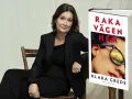 Klara Grede, författaren till "Raka vägen hem", sitter i en stol bredvid sin bok.