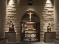 En kyrka från medeltiden med en krucifix, helgonstatyer och altarskåp.