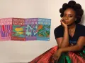 Chimamanda Ngozi Adichie sitter bredvid sina böcker, inklusive "Lila hibiskus".