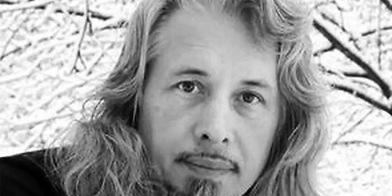 Vladimir Sorokin, med sitt långa hår och skägg, blickar ut mot en snötäckt vinterbakgrund.