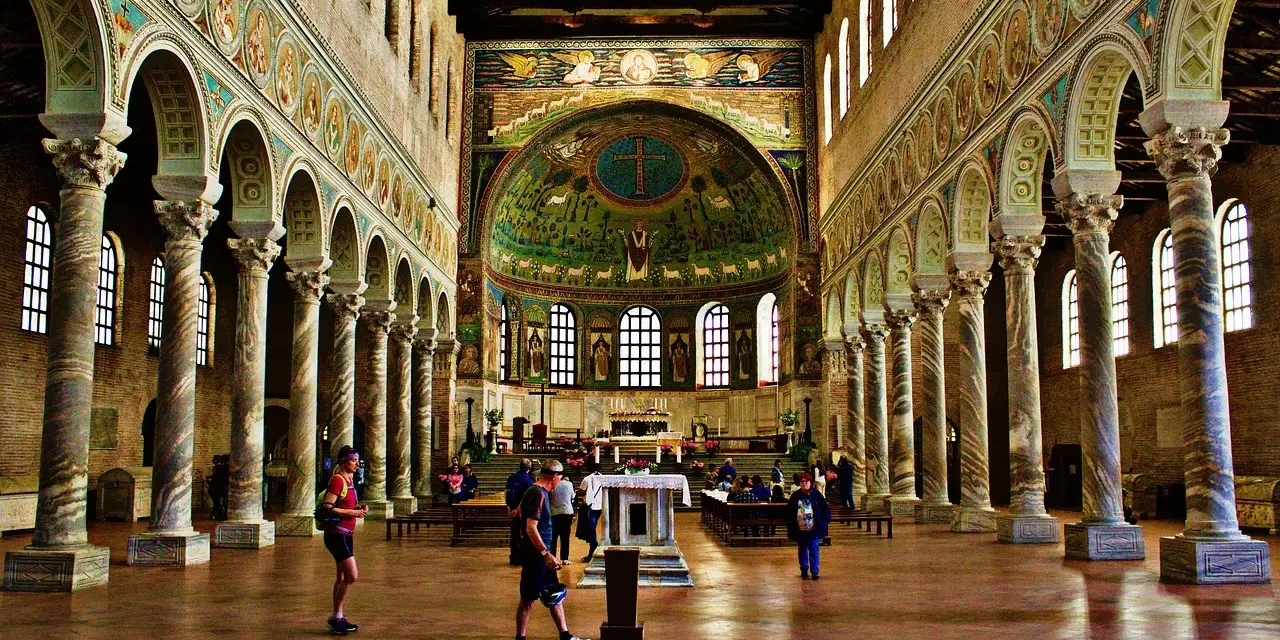 Interiör av en basilika med mosaiker. En man som heter Dante går förbi en pelarrad.