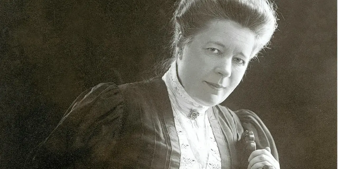 Selma Lagerlöf, med sin karaktäristiska frisyr och klädedräkt, blickar mot betraktaren.