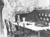 Paul Verlaine sitter vid ett bord med en hatt och en flaska.