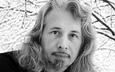 Vladimir Sorokin, med sitt långa hår och skägg, blickar ut mot en snötäckt vinterbakgrund.