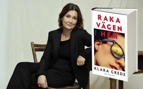 Klara Grede, författaren till "Raka vägen hem", sitter i en stol bredvid sin bok.