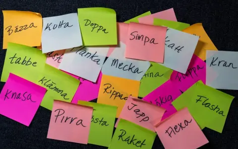 En hög med färgglada post-it-lappar med gamla svenska slangord som "Bäzza", "Kotta", "Doppa", "Simpa", "Tabbe", "Planka", "Mecka", "Kran", "Knasa", "Flasha", "Pirra", "Japp", "Raket" och "Flexa".