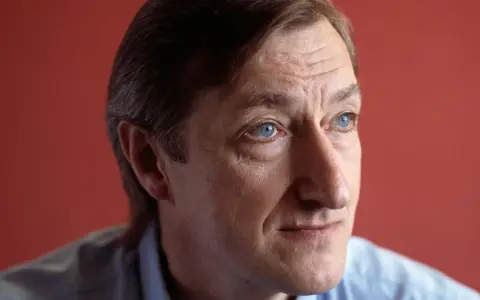Julian Barnes, med sina blå ögon och rynkor som vittnar om livets gång, blickar ut mot horisonten.
