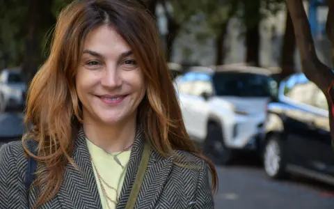 Viola Ardone ler glatt ut mot kameran, klädd i en rutig kavaj och en ljusgul tröja.