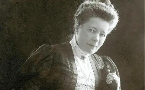 Selma Lagerlöf, med sin karaktäristiska frisyr och klädedräkt, blickar mot betraktaren.