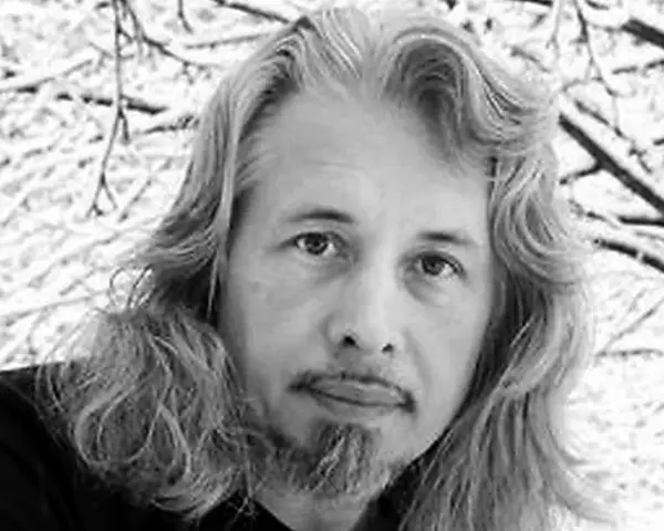 Vladimir Sorokin, med sitt långa hår och skägg, blickar ut mot en snötäckt vinterbakgrund.