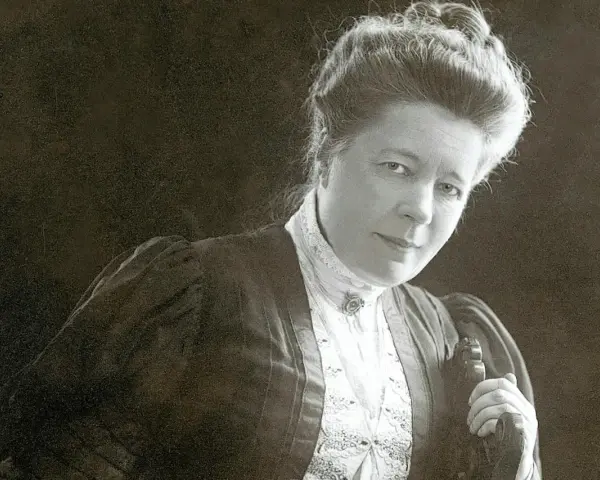 Selma Lagerlöf, med sin karaktäristiska frisyr och klädedräkt, blickar mot betraktaren.