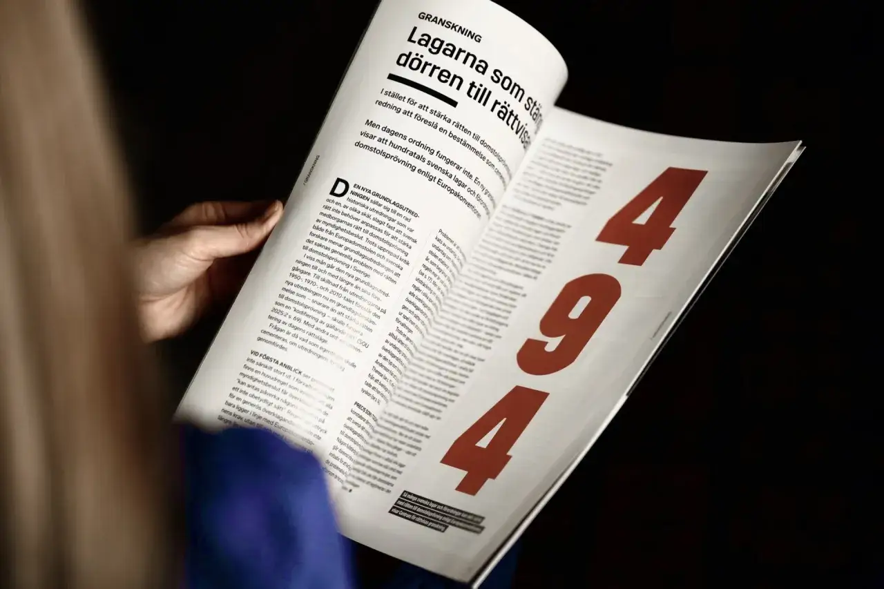 En hand håller i en tidning med rubriken